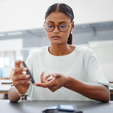 woman using blood glucose meter