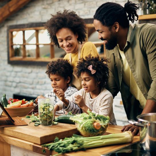 A happy family cooking veggies in a kitchen