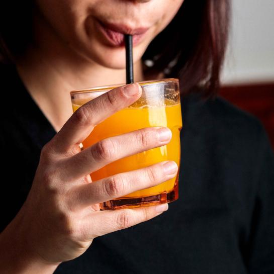 A woman drinking juice out of a glass