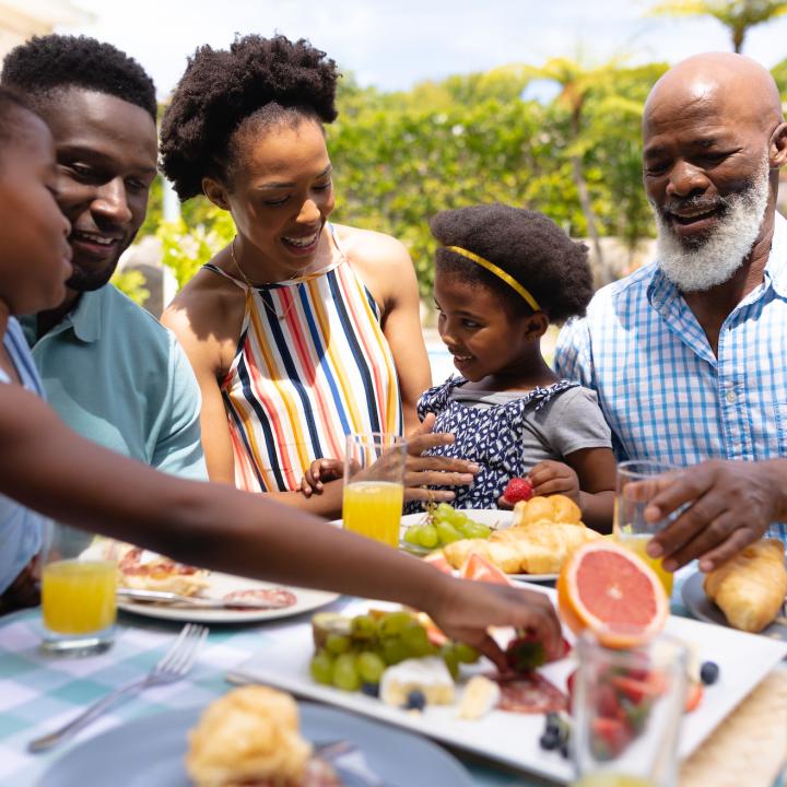 African American family enjoying lunch outside on a sunny day