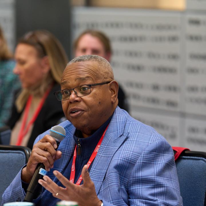 Man with microphone speaking to group