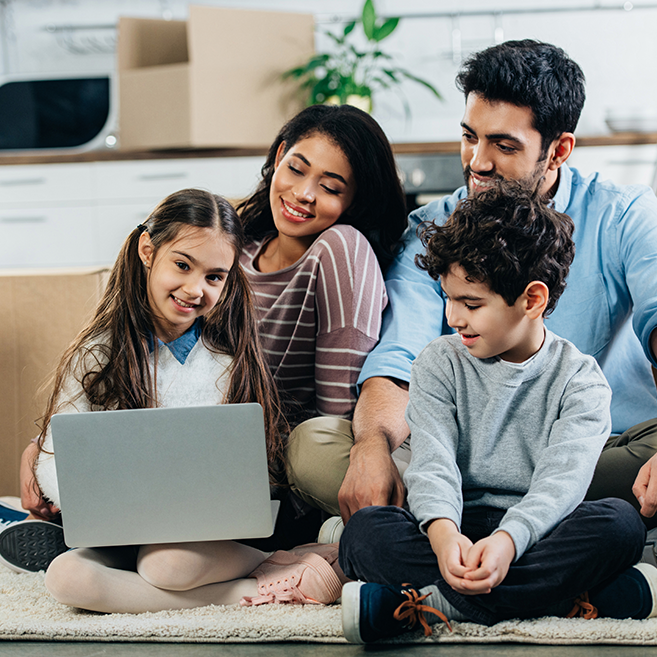 Smiling young Latino family looking at laptop computer