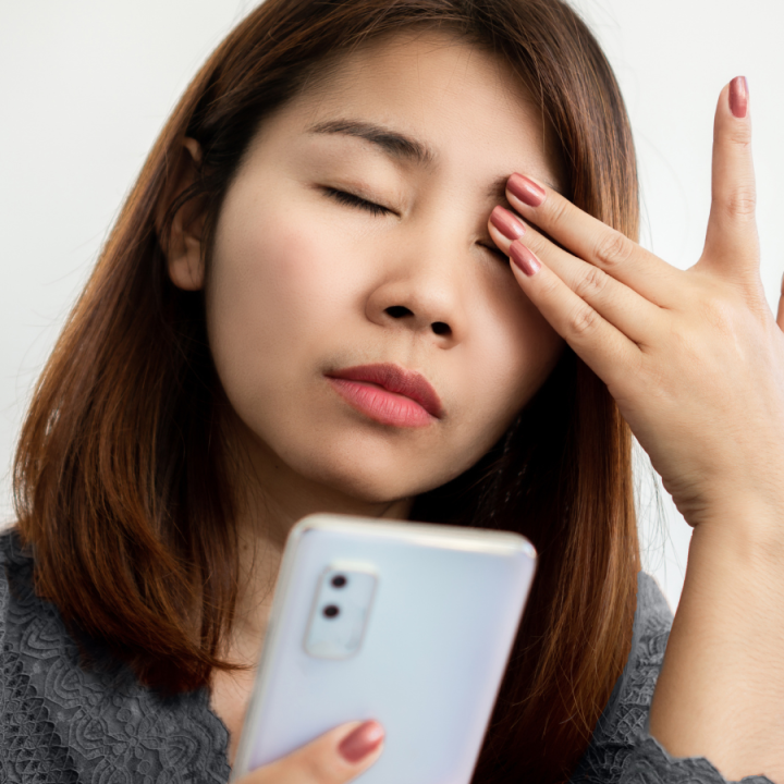 A woman rubs her head due to eye pain and headache