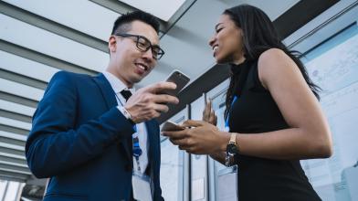 A man and woman looking at a phone and smiling.