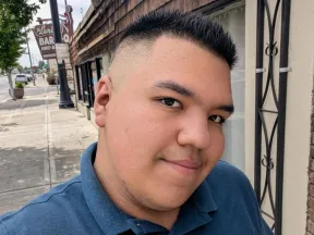 Selfie of Jose walking on a sidewalk.