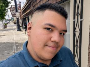 Selfie of Jose walking on a sidewalk.