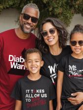 A family of four stands in front of a leafy green wall. The father wears a dark red t-shirt that says "Diabetes Warrior" in white letters. The mother wears a black t-shirt that says "We Fight" in white letters. The young son wears a black t-shirt with the words "It Takes All of Us to Stop Diabetes" written on it. The young daughter wears a black t-shirt with the words "We Fight" in white letters. All are smiling and wearing sunglasses.