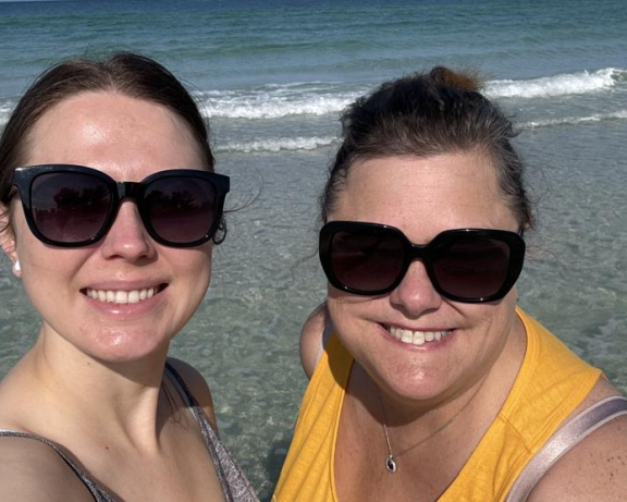 Close up photo of Leora and a friend on a beach