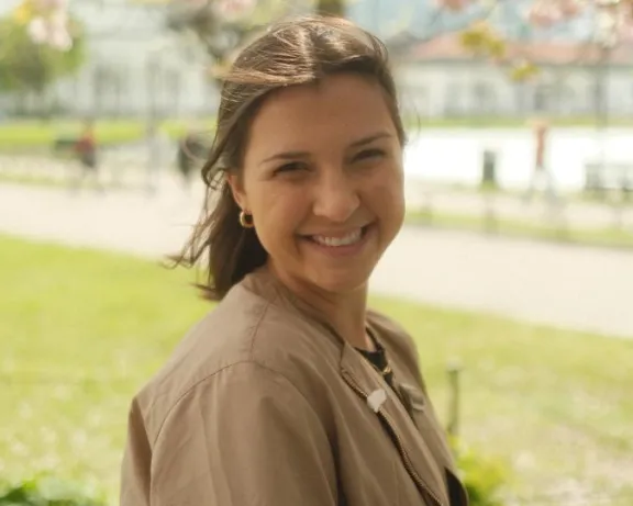 a smiling girl with brown hair on a spring day