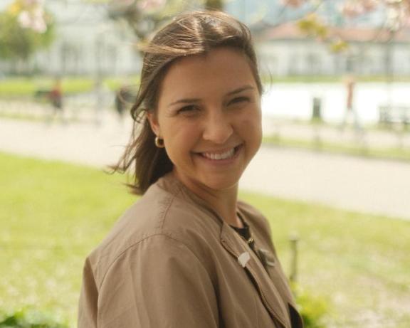 a smiling girl with brown hair on a spring day