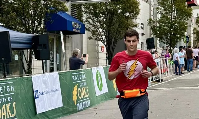 Photo of Robert crossing a marathon finish line