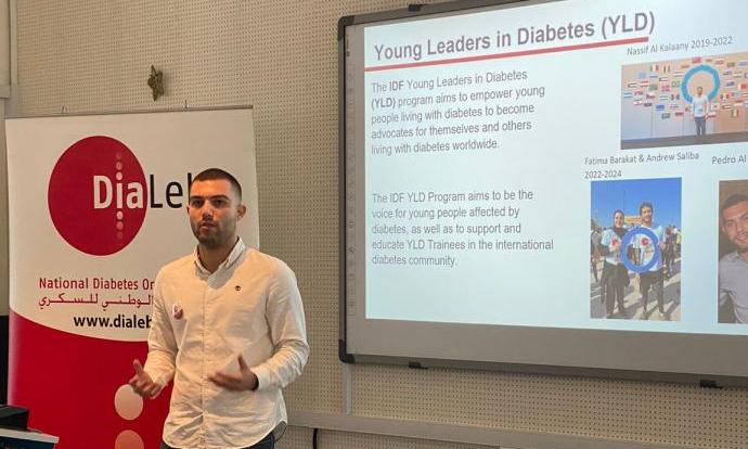 A man presenting in front of a screen about young leaders in diabetes.