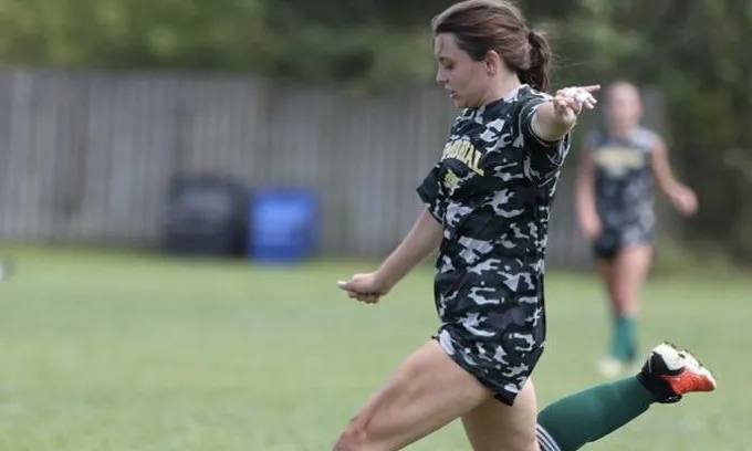 Girl playing soccer on a field.