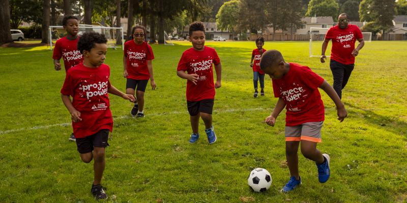 A group of kids in the Project Power youth program playing soccer
