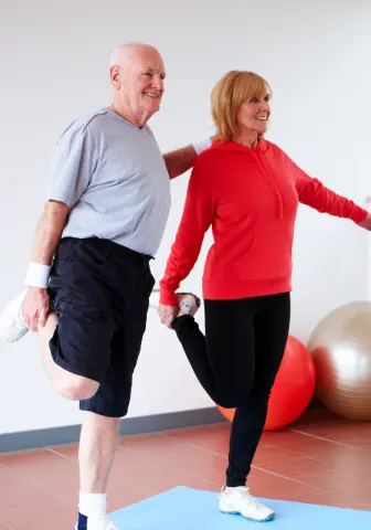 Two seniors balancing on one leg