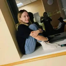 Photo of Ulyssia sitting with her legs folded to her chest