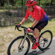 Don riding a bicycle on a road