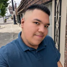 Selfie of Jose walking on a sidewalk.