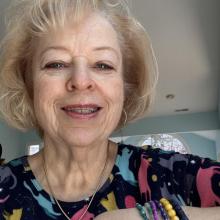 a woman with blond hair smiles at the camera