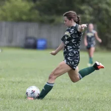 Girl playing soccer on a field.