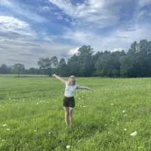 Woman with her arms spread out standing in a field