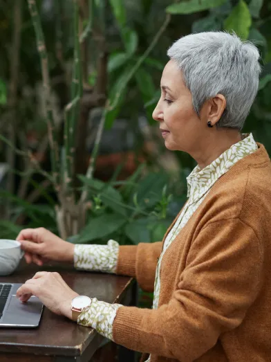 woman sitting in garden at the computer