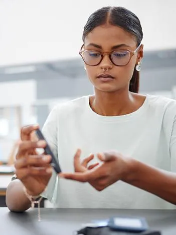 woman using blood glucose meter