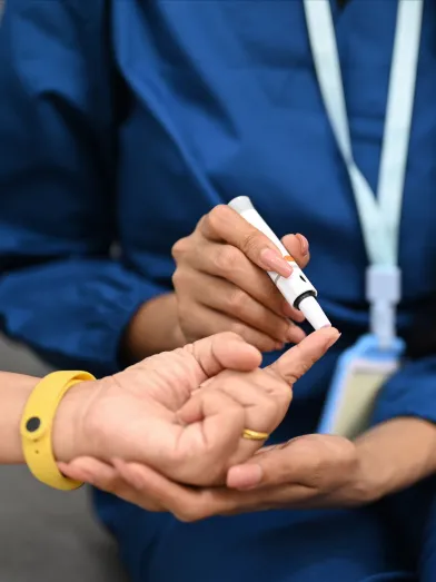 Nurse testing a patient's blood glucose with lancet