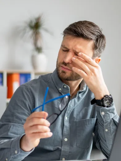 A man rubs at his dry eyes caused by diabetes related dry eye syndrome