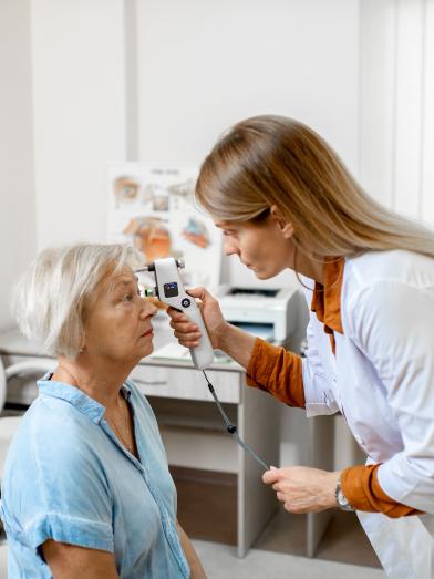 A doctor checks the eye pressure of a senior woman for diabetic eye disease