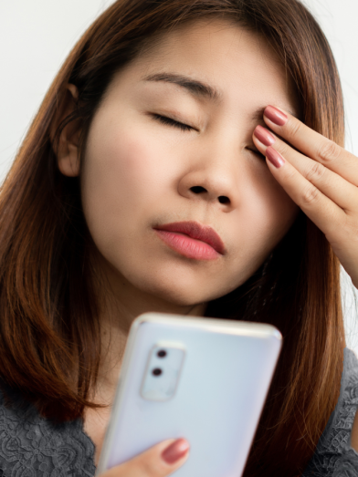 A woman rubs her head due to eye pain and headache