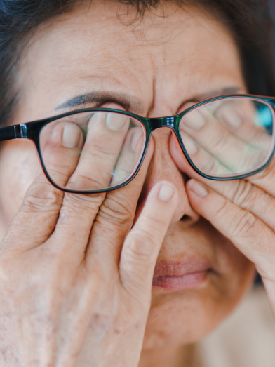 A woman rubs her eyes due to floaters in her vision from diabetes related eye disease