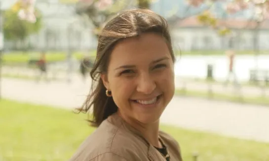 a smiling girl with brown hair on a spring day