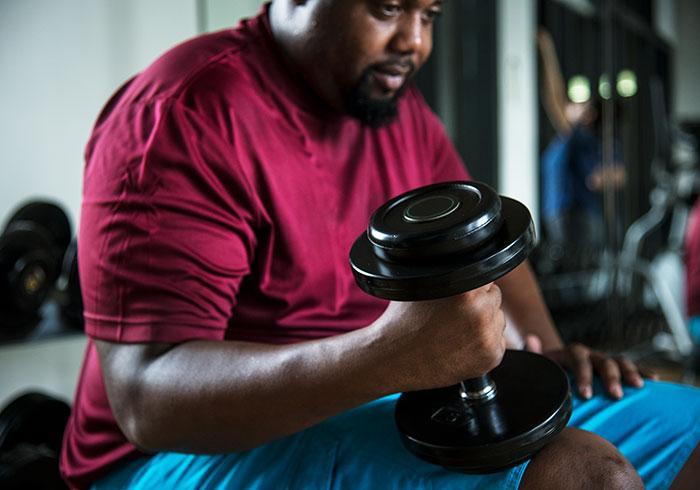 Man in gym lifting dumbbells